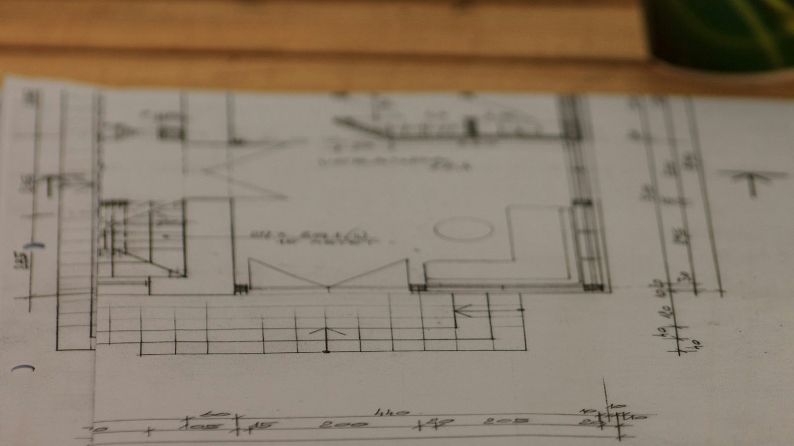 Printed floor plans stacked on a wooden table