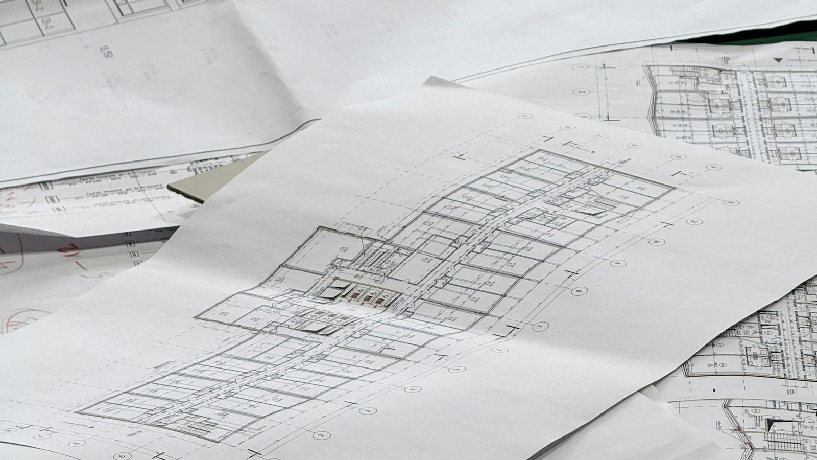 A set of architectural drawings spread across a work surface