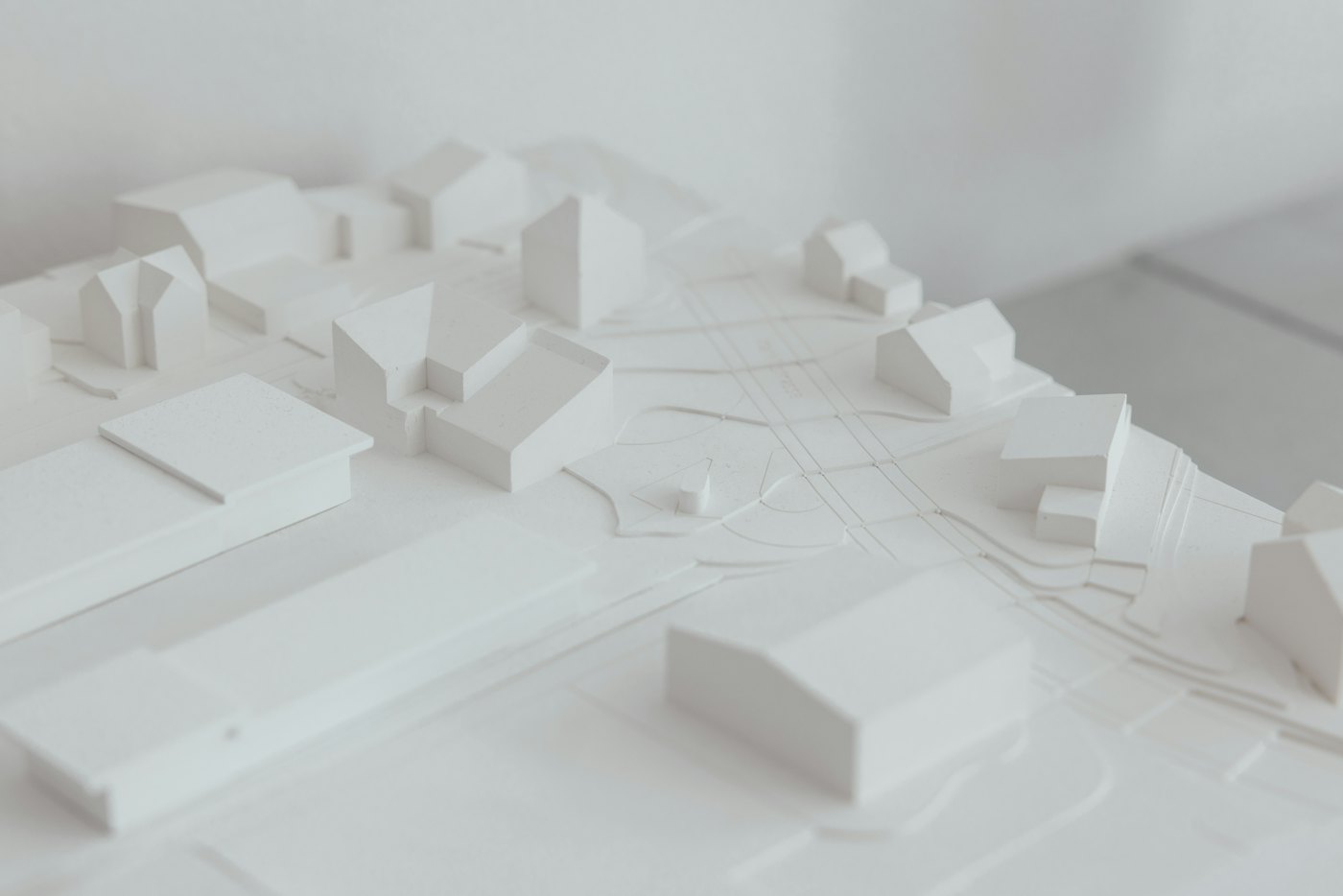 A white site model of low buildings and streets seen from above at an angle