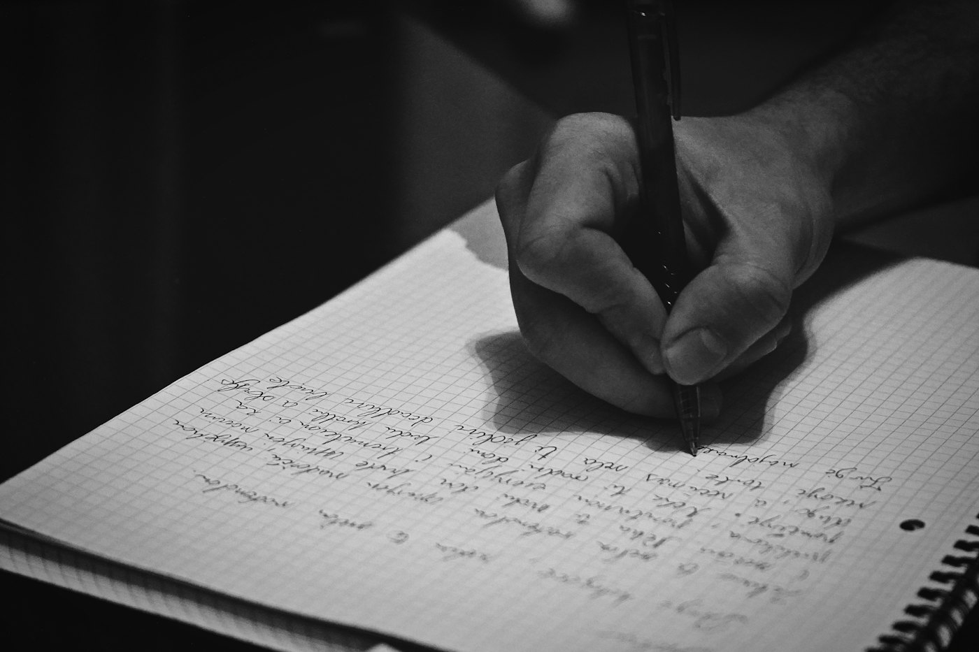 A hand writing notes in an open notebook