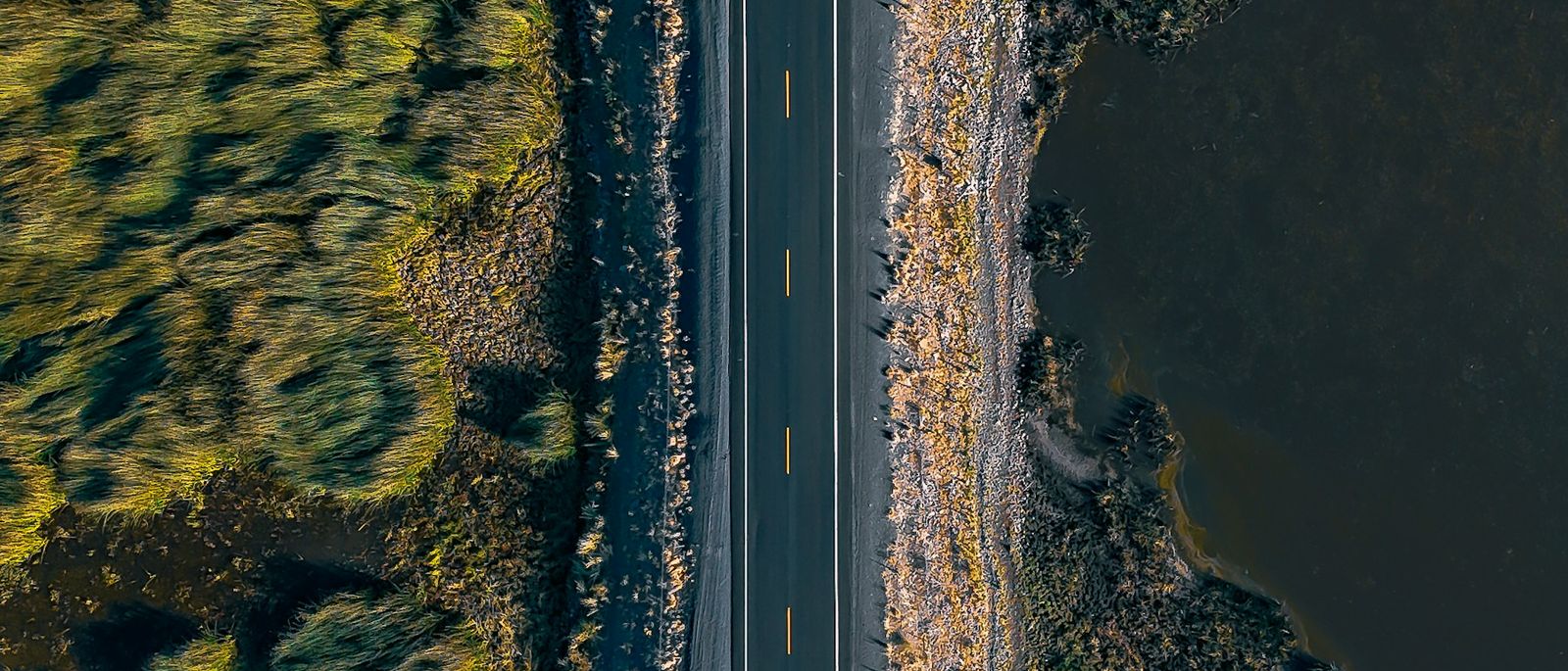 Seen from above, a single straight road runs through open, empty ground