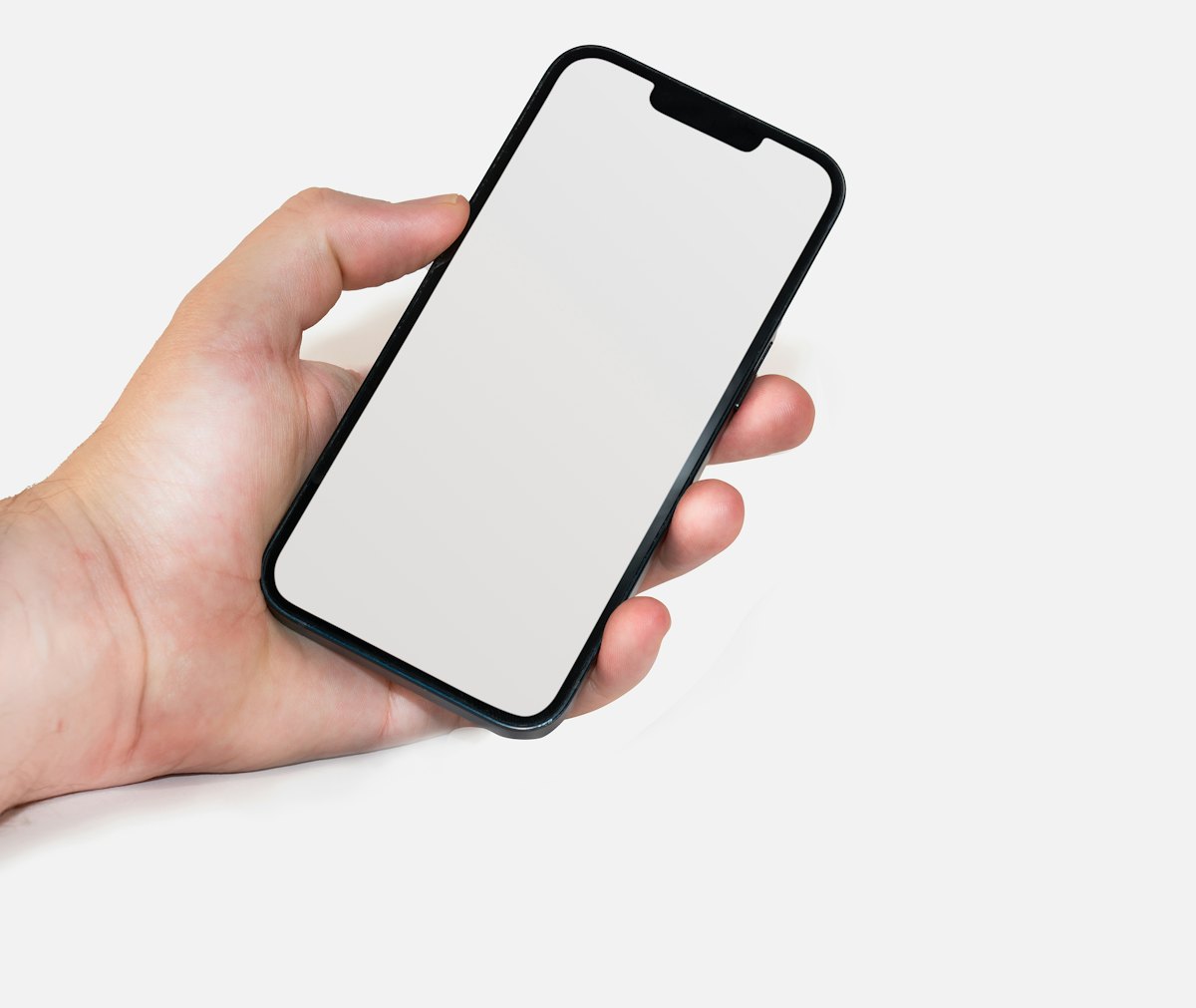 A hand holding a phone with a blank screen