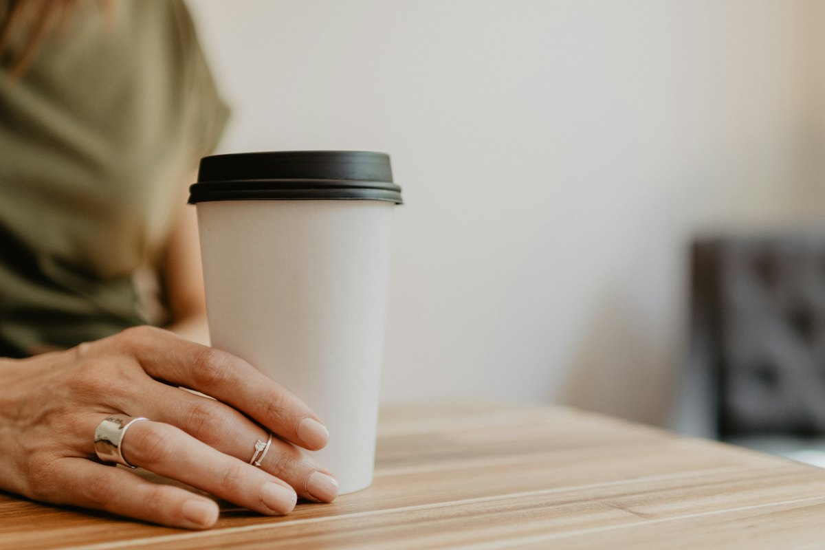 A plain takeaway cup held in a hand
