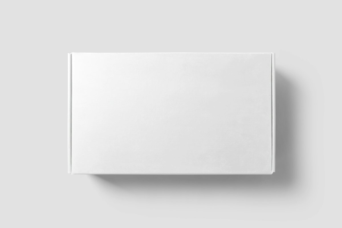 A plain white mailer box on a pale surface