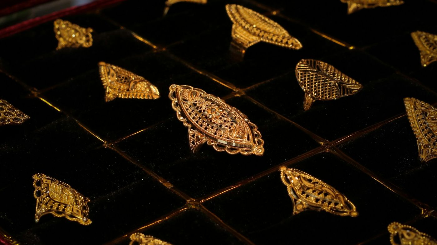 Ornate gold rings set in rows on a black velvet tray