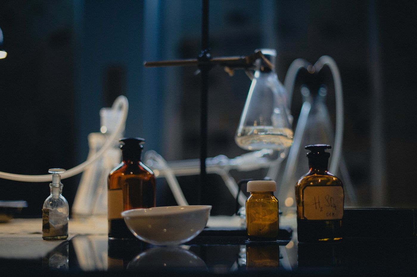 Amber reagent bottles, flasks and tubing on a laboratory bench