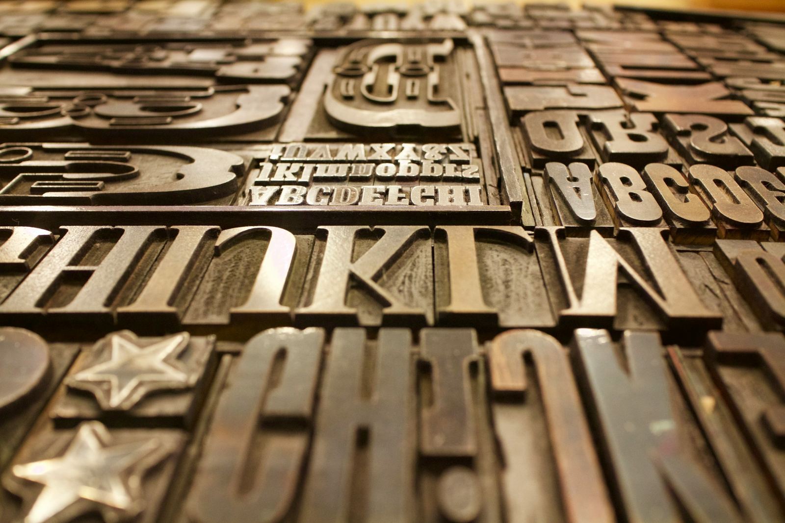 Rows of large wooden printing letters and ornaments in a print shop.