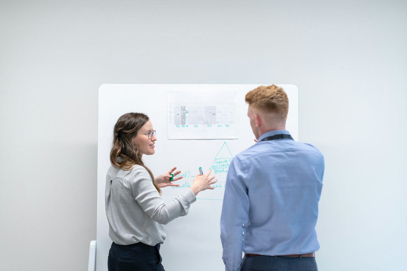 An engineer sketches a system diagram on a whiteboard during a working session