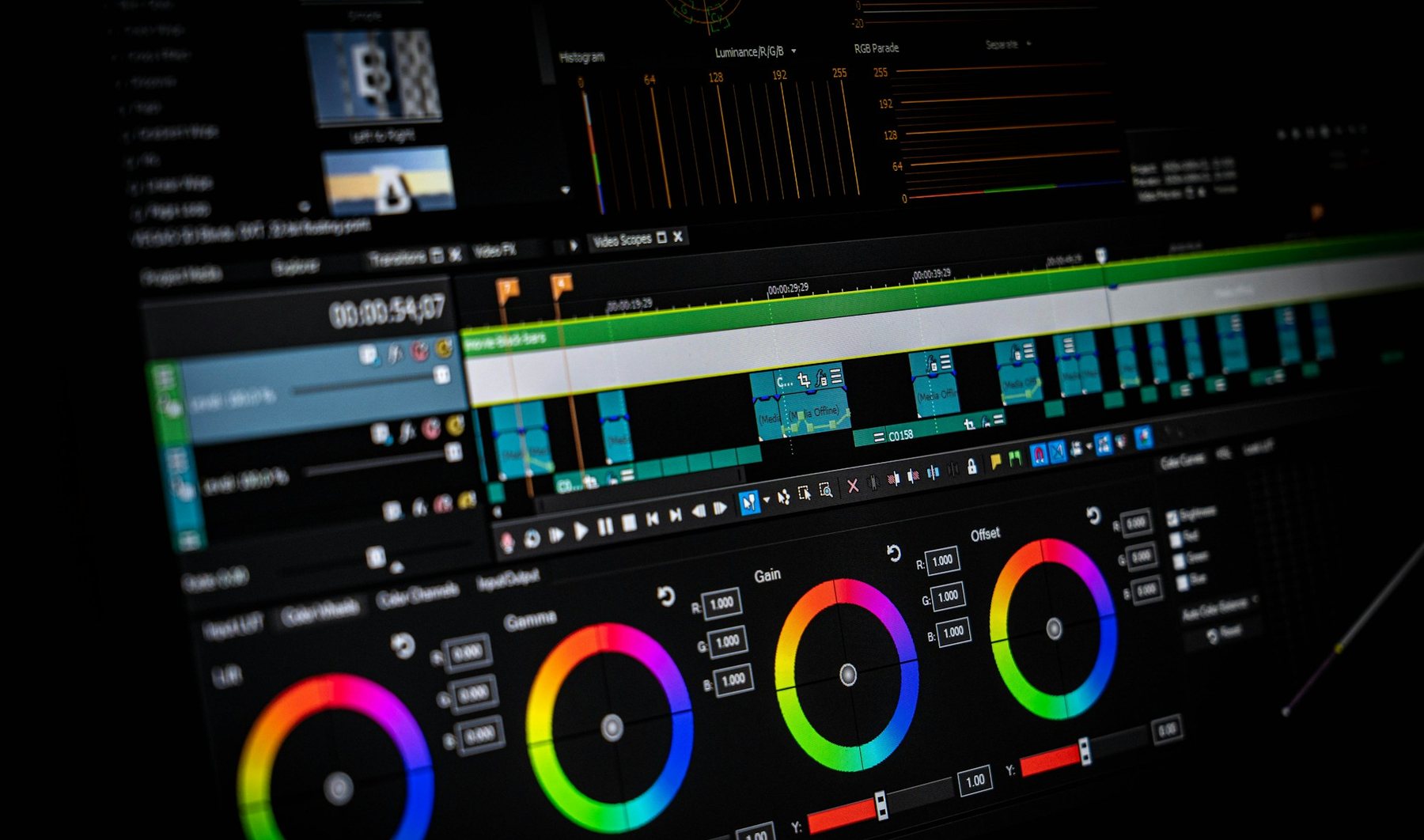 Colour wheels, scopes and a timeline on a grading screen in a dark suite