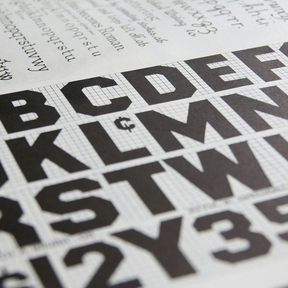 A type specimen book: bold capitals and figures on a grid.