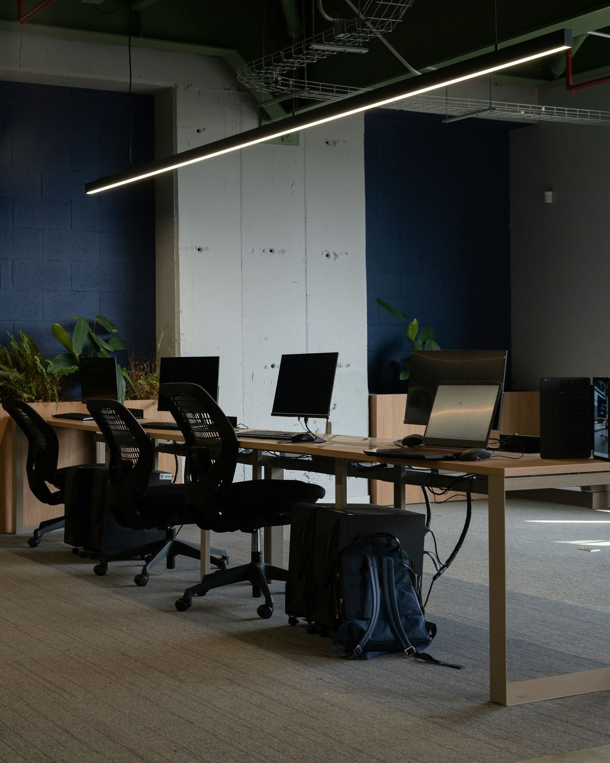 An empty office with a long table, chairs and screens, waiting for the day to start.