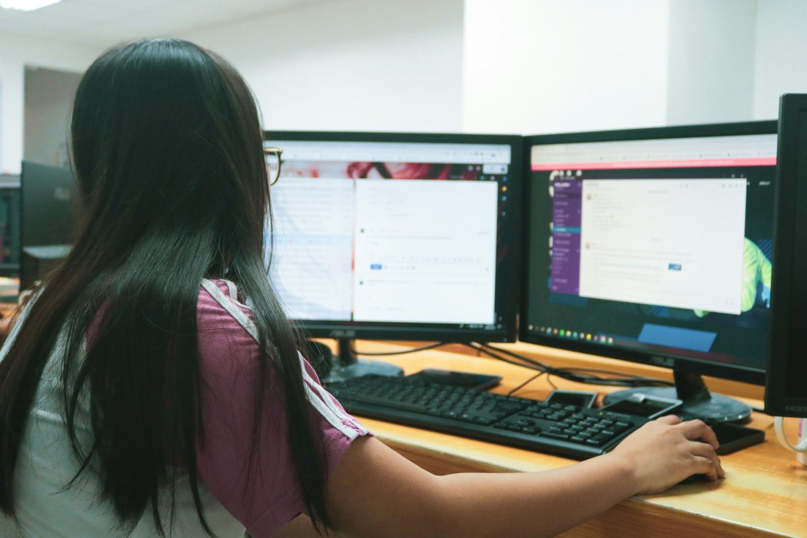 An operations analyst working across two wide monitors