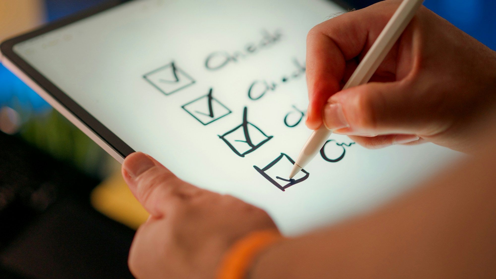 A hand ticks the last box of a handwritten checklist on a tablet with a stylus.